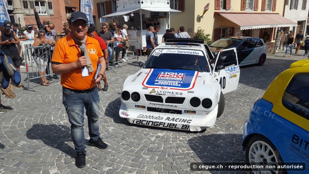 Cédric Gueniat au micro près d’une voiture de course à St-Ursanne